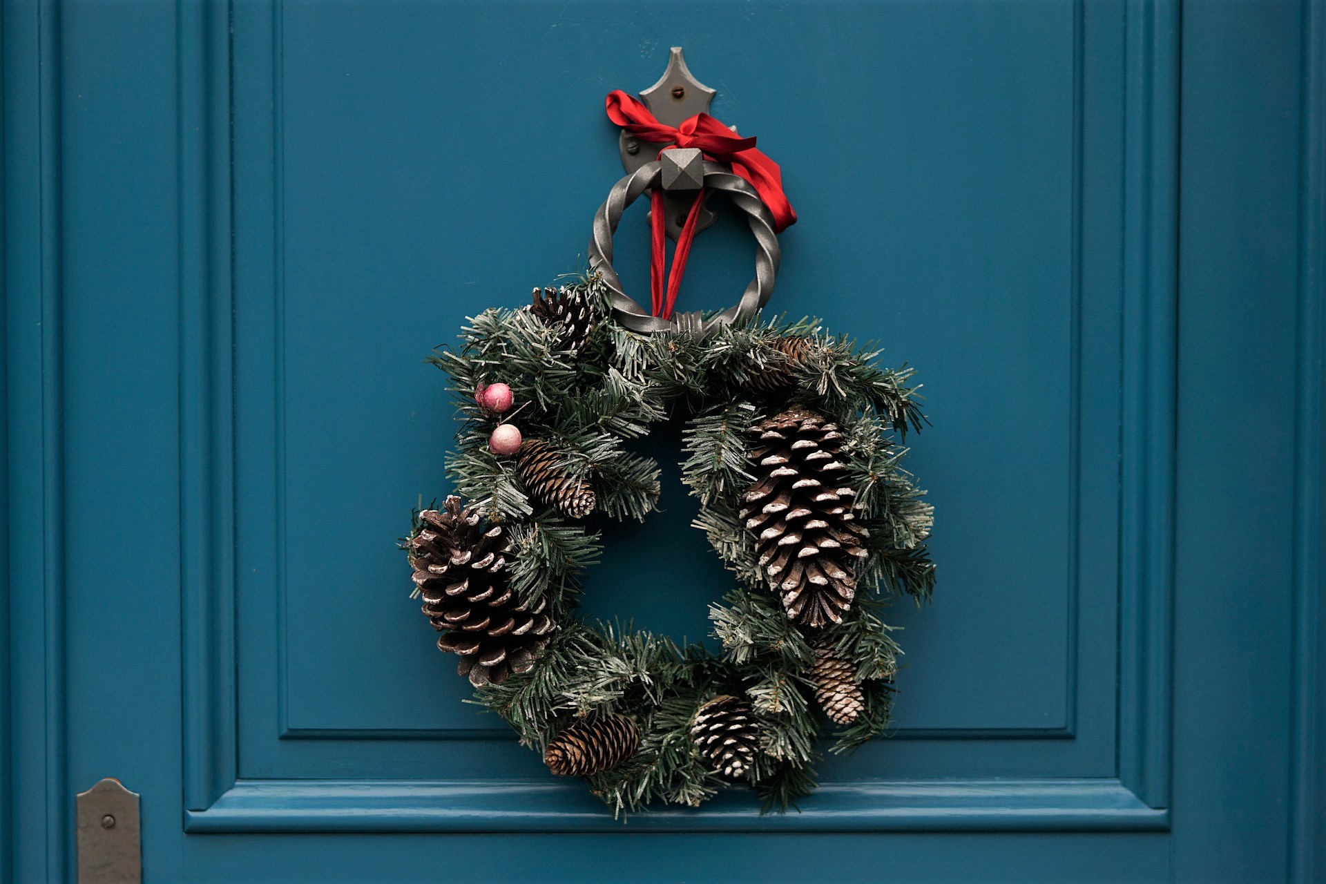 Photo d'une joilie couronne de Noël naturelle accrochée sur une porte bleue