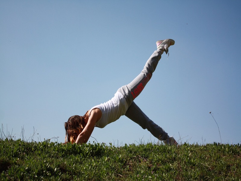 Photo d'une personne en posture de yoga sur l'herbe